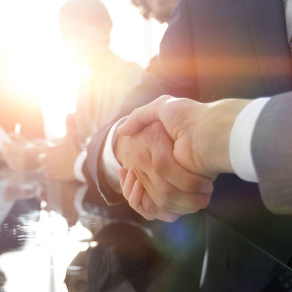 background image of handshake of business partners in conference room